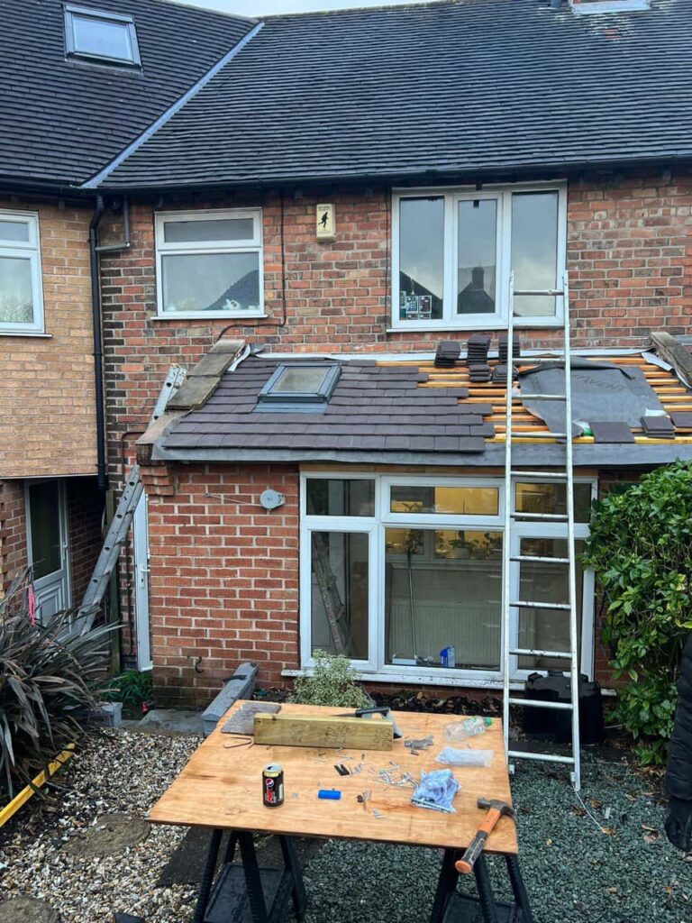 This is a photo of a roof extension that is having new roof tiles installed. This is a photo taken from the roof ridge looking down a tiled pitched roof on to a flat roof. Works carried out by Tuxford Roofing Repairs