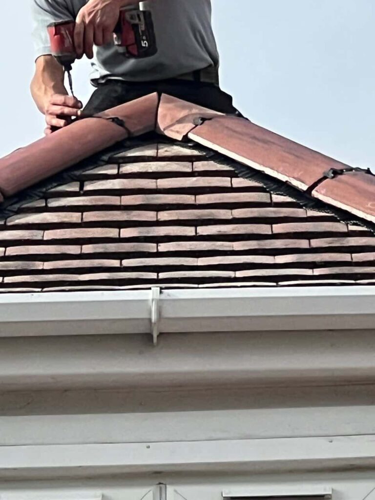 This is a photo of one of the operatives of Tuxford Roofing Repairs installing new ridge tiles